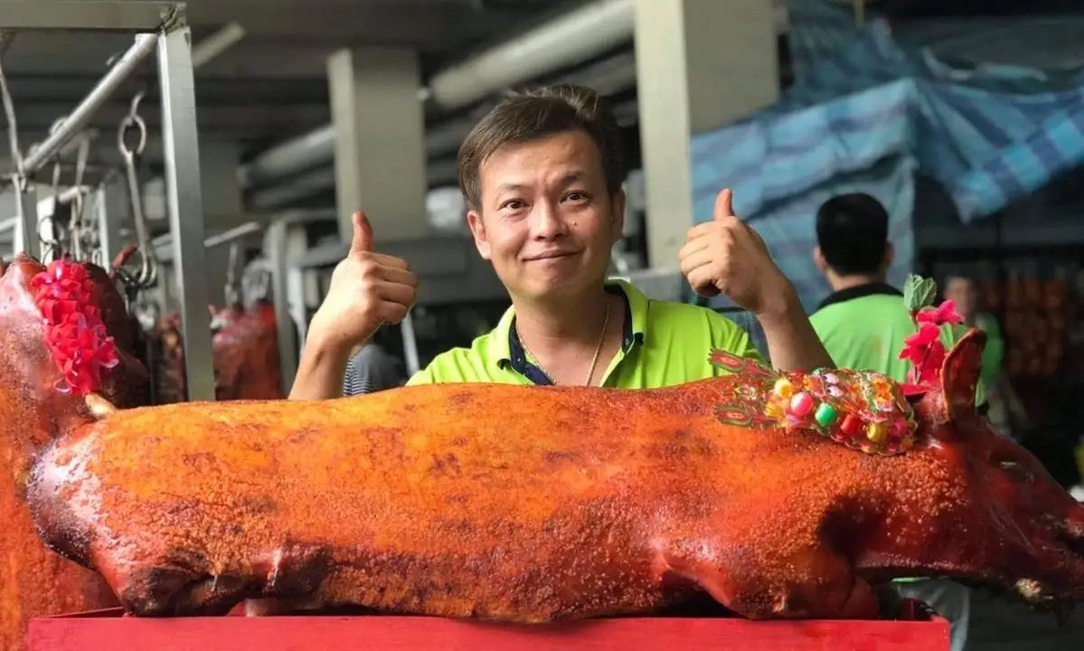 CHARROU founder with traditional roasted pig showcasing heritage and expertise